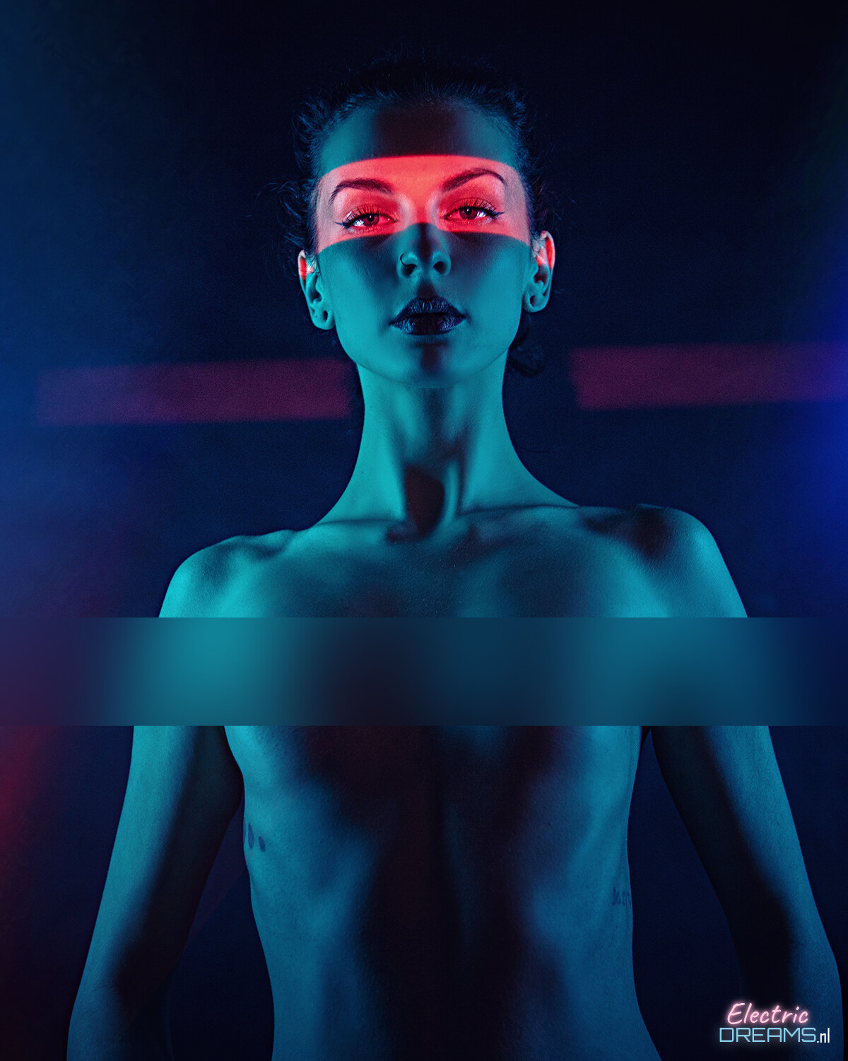 The image shows a woman with red and blue lights on her face against a dark background, with a watermark in the bottom right corner.
